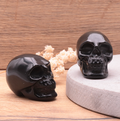 Schwarzer Obsidian Schädel-Duo „Eternal Shield“ – Handgeschnitzte Kraftsymbole (50 mm)